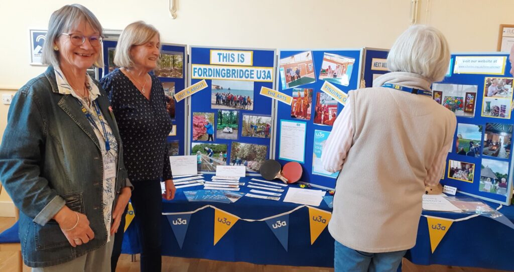 three people by u3a display boards