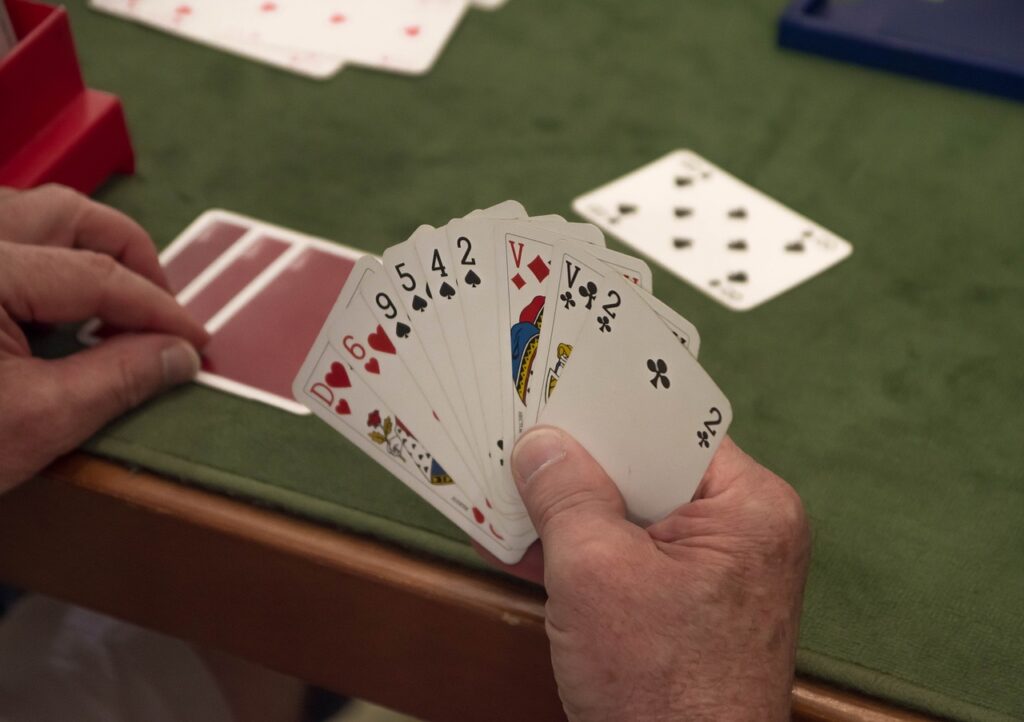 A hand of cards held near a card table